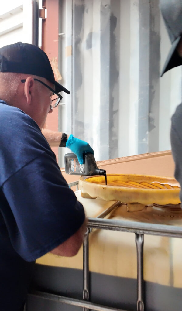 Chuck's Employee empties oil into our storage tanks during our annual Earth Day Collections! - 2025